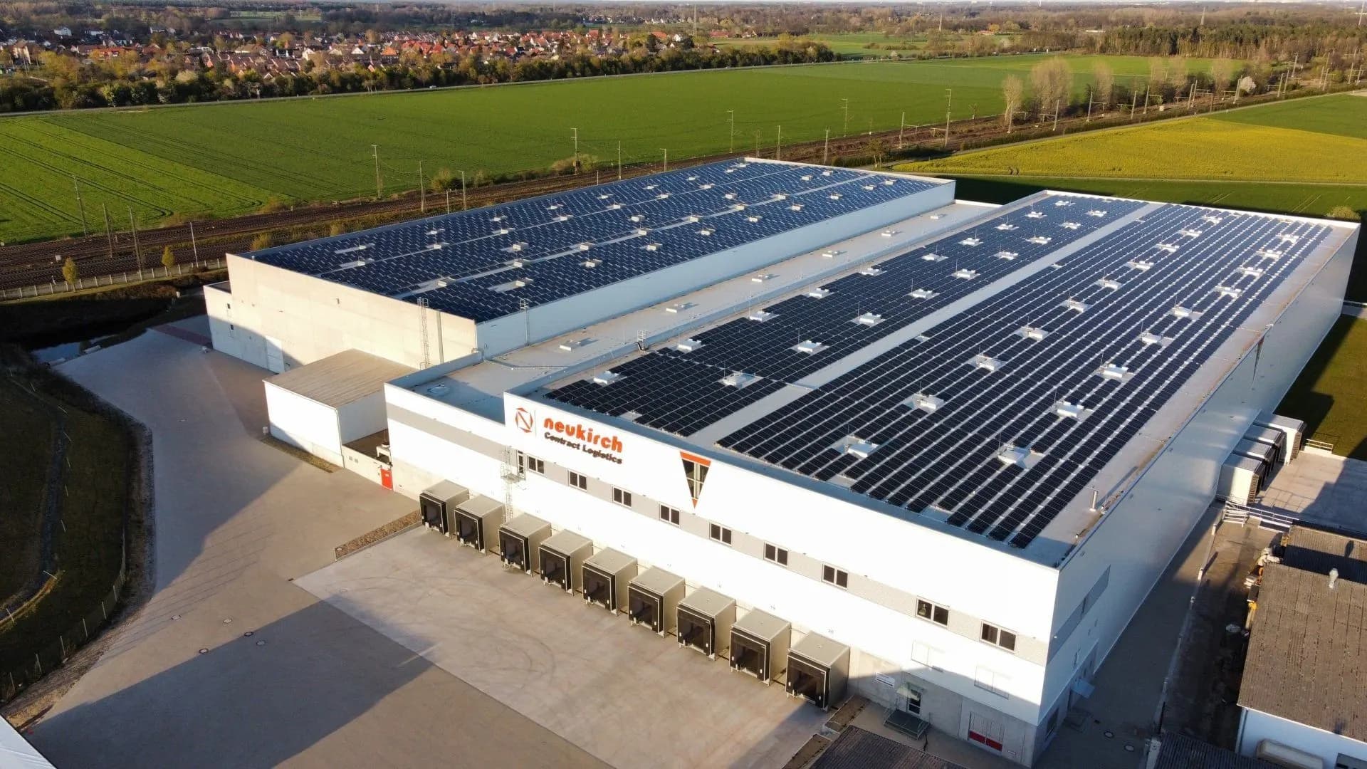 Luftaufnahme der Neukirch Logistikhalle mit Photovoltaik-Dach und Verladerampen in Wunstorf
